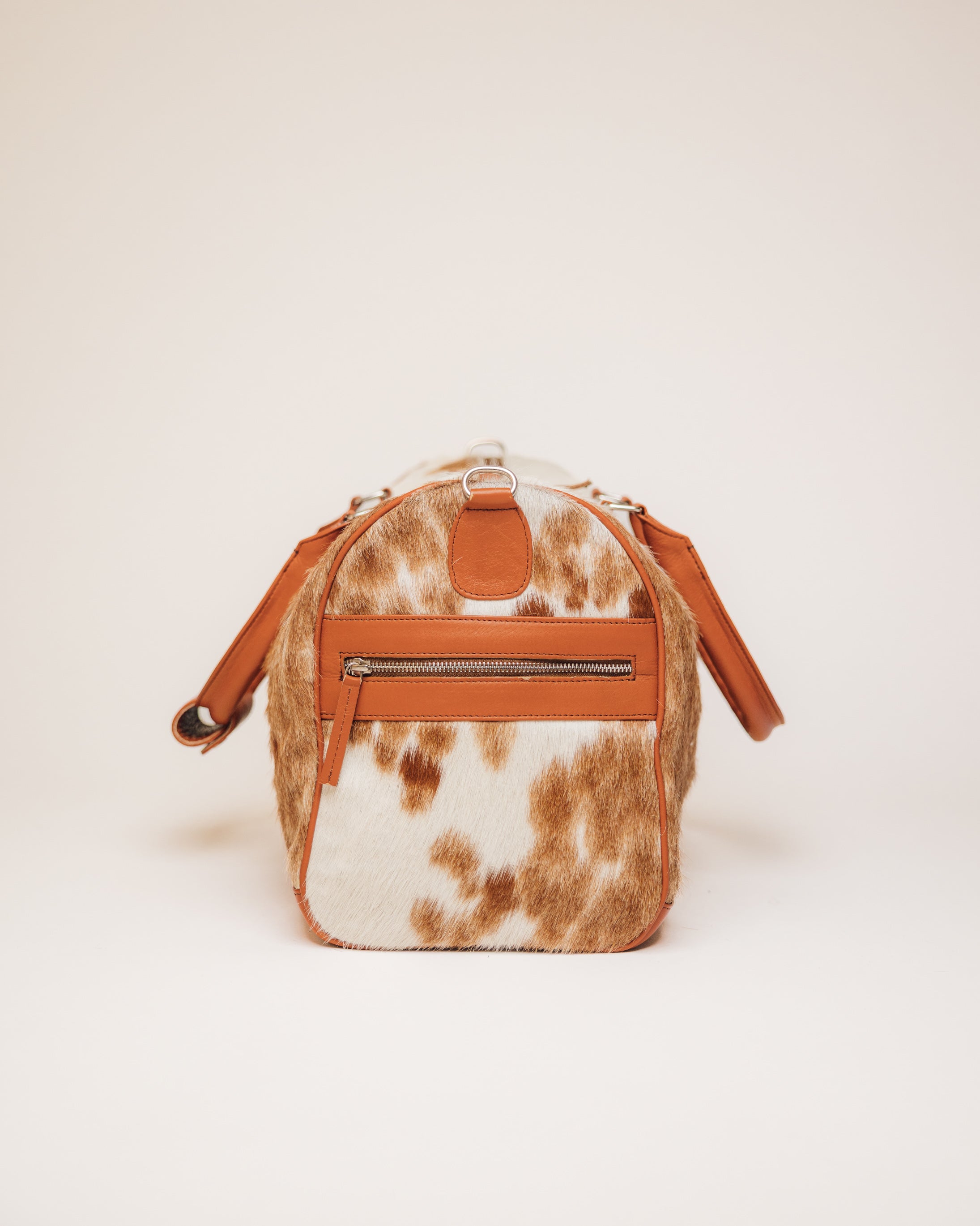 Red Angus cowhide duffle carried by shoulder strap
