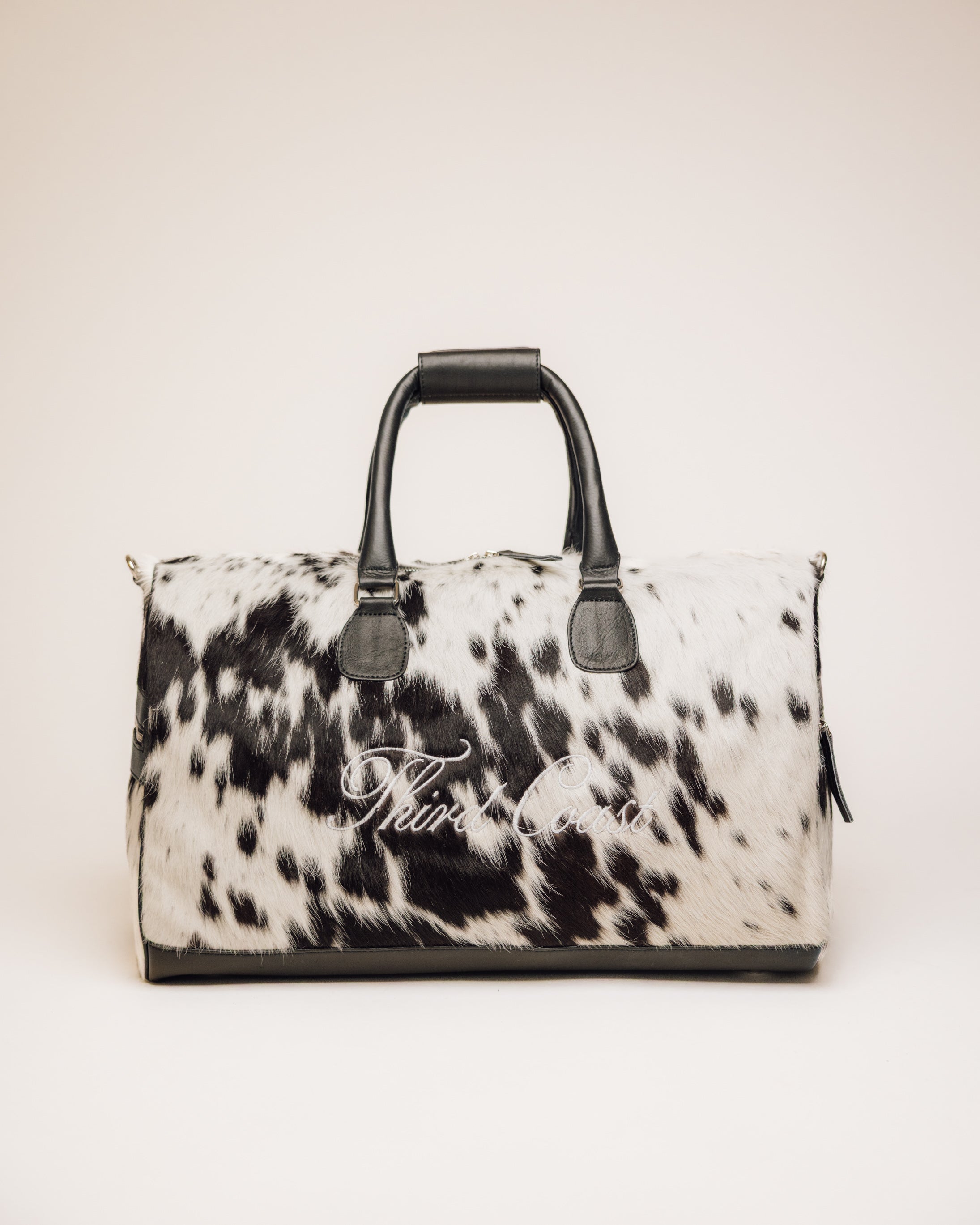 Black and white cowhide duffle bag with full-grain leather trim