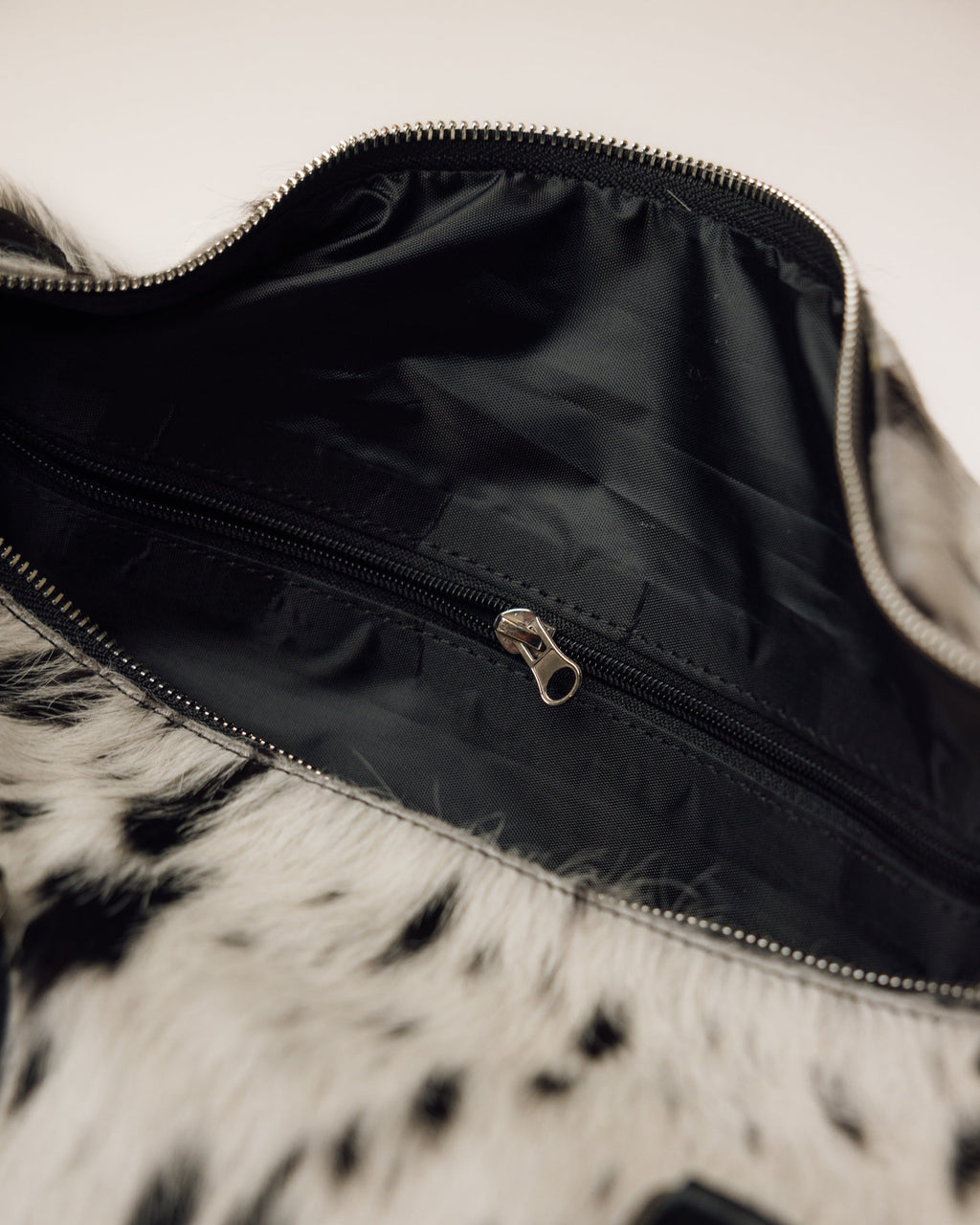 Cowhide duffle bag with luggage tag, black and white hide