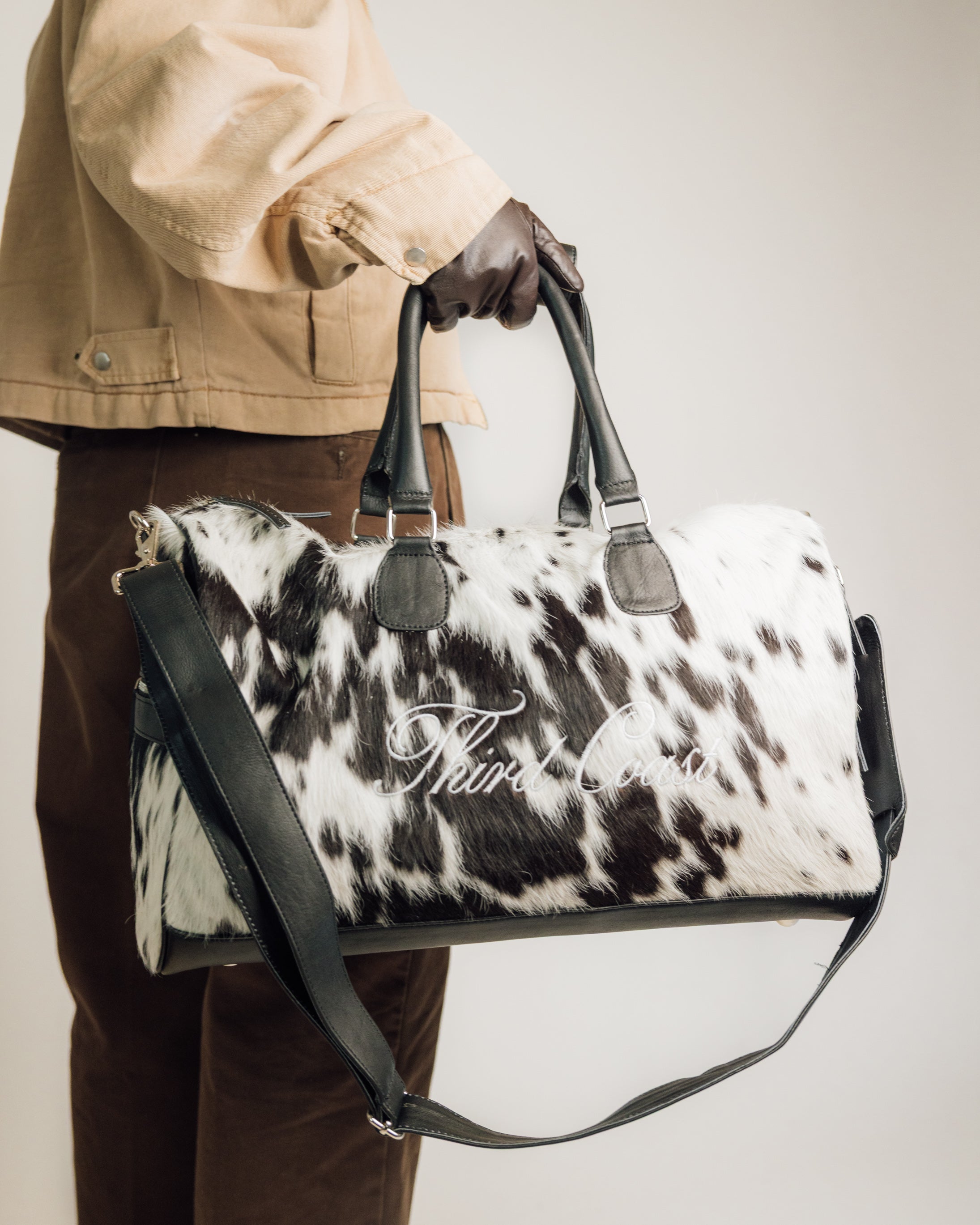 Black and white cowhide duffle styled with western apparel