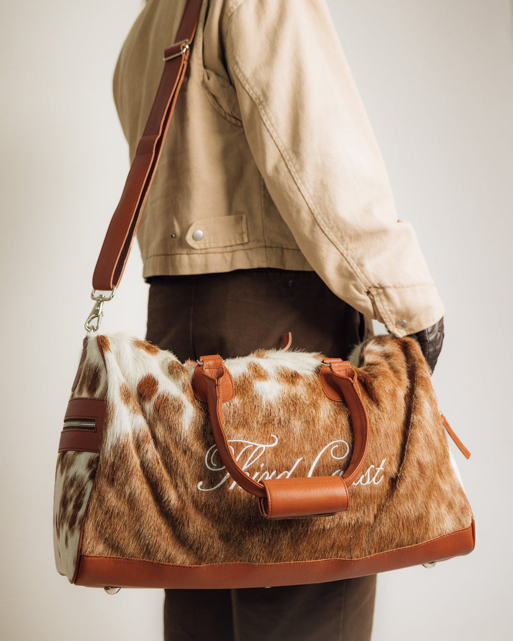 Red Angus cowhide duffle, end panel and handle detail