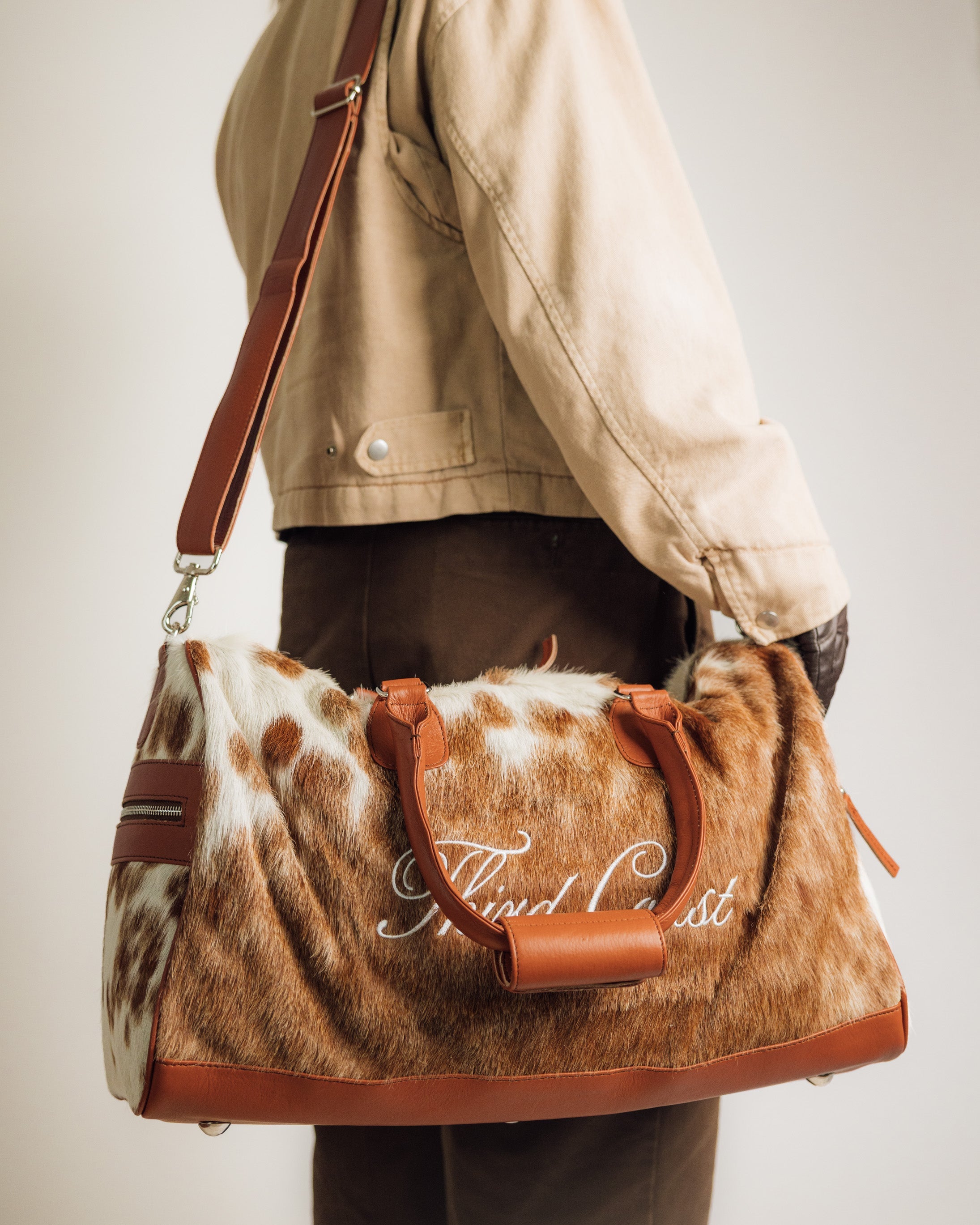 Red Angus cowhide duffle, end panel and handle detail