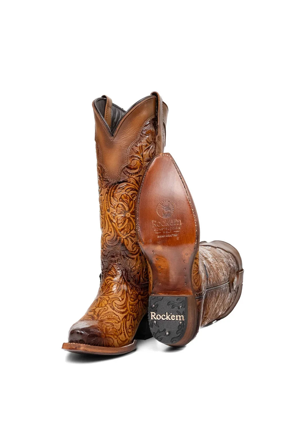 Sole and rubber heel cap of tan tooled leather cowgirl boot